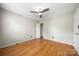 Neutral bedroom featuring a ceiling fan, hardwood floors, and natural light at 15001 Arrowgrass Way, Charlotte, NC 28278