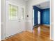 Bright foyer with hardwood floors, decorative glass door, and view of a blue accent wall at 15001 Arrowgrass Way, Charlotte, NC 28278
