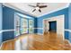 Open living space with hardwood floors, a ceiling fan, and large bay windows at 15001 Arrowgrass Way, Charlotte, NC 28278