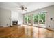 Empty living room featuring hardwood floors, a fireplace, large windows, and natural light at 15001 Arrowgrass Way, Charlotte, NC 28278