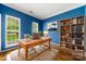 Stylish office with hardwood floors, blue walls, a wooden desk, and built-in bookshelves at 15001 Arrowgrass Way, Charlotte, NC 28278