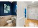 Stylish powder room featuring elegant fixtures, artwork, and a modern design with blue accent wall and beautiful tile at 15001 Arrowgrass Way, Charlotte, NC 28278
