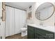 Bathroom features a vanity with green cabinets, modern sink and mirror, and shower with white curtain at 1555 Ridgewood Dr, Gastonia, NC 28054