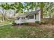 Well-maintained home with a covered front porch, a green lawn, and mature trees at 1555 Ridgewood Dr, Gastonia, NC 28054