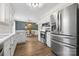 Modern kitchen showcasing stainless steel appliances, white cabinetry, and a seamless flow to the dining area at 1555 Ridgewood Dr, Gastonia, NC 28054