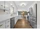 Bright kitchen features white cabinets, stainless steel appliances and a dining area with wallpapered accent wall at 1555 Ridgewood Dr, Gastonia, NC 28054
