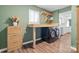 This laundry room features modern washer and dryer, folding table, shelves and wood-look floors at 1555 Ridgewood Dr, Gastonia, NC 28054