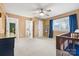 Main bedroom featuring a ceiling fan, large window with blue curtains, and ensuite bathroom at 1555 Ridgewood Dr, Gastonia, NC 28054