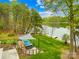 Lush backyard features a deck with a hot tub, fire pit, and easy access to the serene lake at 158 Regency Rd, Mooresville, NC 28117