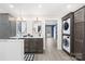 Bathroom with double vanity, glass shower, stackable washer/dryer, and wood-look flooring at 158 Regency Rd, Mooresville, NC 28117