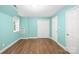 Inviting bedroom features wood flooring and a spacious closet with bright teal painted walls at 158 Regency Rd, Mooresville, NC 28117