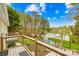 Wooden deck overlooks a hot tub and lake view, surrounded by lush greenery at 158 Regency Rd, Mooresville, NC 28117