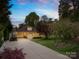 Charming home showcasing a manicured lawn, mature trees, and a long driveway leading to a lovely facade at 158 Regency Rd, Mooresville, NC 28117