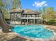 Exterior shot of the backyard featuring a pool with slide and elevated back porch at 1725 Hannon Farm Rd, Fort Mill, SC 29715