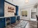 Modern bar area featuring blue cabinets, wine coolers, and floating wood shelves at 1725 Hannon Farm Rd, Fort Mill, SC 29715