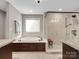 Modern bathroom showcasing a soaking tub with tile surround and a glass-enclosed walk-in shower at 1725 Hannon Farm Rd, Fort Mill, SC 29715