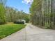 Long concrete driveway leading to a detached structure with a well-maintained lawn and mature trees at 1725 Hannon Farm Rd, Fort Mill, SC 29715