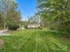 Expansive front yard featuring well-maintained lawn, mature trees, and a detached structure with a basketball hoop at 1725 Hannon Farm Rd, Fort Mill, SC 29715