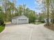 Detached white garage with a concrete driveway, surrounded by mature trees and landscaping at 1725 Hannon Farm Rd, Fort Mill, SC 29715
