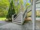 View of back staircase leading to upper level, with decorative railing and manicured landscaping at 1725 Hannon Farm Rd, Fort Mill, SC 29715