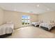 Large bedroom with three beds, light wood floors and a large window looking out onto the lake at 239 Paradise Peninsula Rd, Mooresville, NC 28117