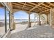 Stunning stone patio with lake views featuring stone columns and wood beam ceiling at 239 Paradise Peninsula Rd, Mooresville, NC 28117