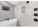 Bright bathroom features a modern soaking tub, sleek black fixtures, and natural light from window at 3129 Rush Ave, Charlotte, NC 28208