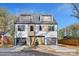 Modern duplex featuring light gray siding, two garage doors, wooden accents and a blue sky at 3129 Rush Ave, Charlotte, NC 28208