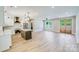 Open-concept living room featuring hardwood floors, large windows, and seamless integration with the kitchen area at 32519 Buchanan Ln, Albemarle, NC 28001