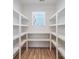 Well-organized pantry with custom shelving, providing ample storage space and a window for natural light at 32519 Buchanan Ln, Albemarle, NC 28001