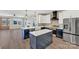 Modern kitchen featuring white cabinets, navy island, stainless steel appliances, and stylish pendant lighting at 32525 Buchanan Ln, Albemarle, NC 28001