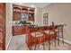 Cozy bar area featuring rich wood finishes, granite countertops, and seating, perfect for entertaining guests at 338 Fairfield Ct, Mount Gilead, NC 27306