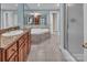 Bright bathroom featuring a soaking tub, walk-in shower and granite-topped vanity with wooden cabinets at 338 Fairfield Ct, Mount Gilead, NC 27306