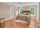 Cozy bedroom boasts hardwood floors, a ceiling fan, and bright windows overlooking the home's lush landscape at 338 Fairfield Ct, Mount Gilead, NC 27306