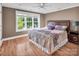 Bedroom featuring hardwood floors, a ceiling fan, bright windows and a large bed with nightstands at 338 Fairfield Ct, Mount Gilead, NC 27306