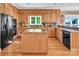 Bright kitchen featuring wooden cabinets, granite countertops, a central island, and modern appliances at 338 Fairfield Ct, Mount Gilead, NC 27306
