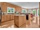 Open kitchen flows to breakfast nook with wood cabinets, granite counters, island, and natural light at 338 Fairfield Ct, Mount Gilead, NC 27306