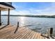 Lakeside view from a wooden dock with blue sky, calm water, and distant trees at 338 Fairfield Ct, Mount Gilead, NC 27306