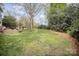 Expansive backyard features a lush lawn, mature trees, and an inviting deck area for outdoor enjoyment at 3409 Pondview Ln, Charlotte, NC 28210