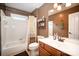 Well-lit bathroom with a bathtub/shower combo, a single sink vanity, and warm brown tones at 3409 Pondview Ln, Charlotte, NC 28210