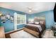 Bright bedroom featuring cool blue walls, a comfortable bed, and a large window with natural light at 3409 Pondview Ln, Charlotte, NC 28210