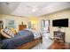 Sunlit bedroom showcasing a ceiling fan, a large window, and a flat screen television at 3409 Pondview Ln, Charlotte, NC 28210