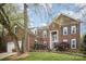 Elegant brick home with dark shutters, lush landscaping, and a well-manicured lawn with lots of trees at 3409 Pondview Ln, Charlotte, NC 28210