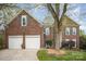 Charming brick home featuring a two-car garage and beautifully mulched landscaping around mature trees at 3409 Pondview Ln, Charlotte, NC 28210