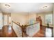 Bright hallway featuring hardwood floors, white railings, and ample natural light from the window at 3409 Pondview Ln, Charlotte, NC 28210