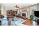 Cozy living room with hardwood floors, a fireplace, a ceiling fan and large windows offering natural light at 3409 Pondview Ln, Charlotte, NC 28210