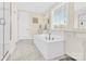 Bright bathroom featuring a white tub, double vanity, and glass shower with neutral tile and fixtures at 345 Somerled Way, Waxhaw, NC 28173