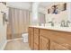 Functional bathroom featuring a double vanity with wooden cabinets and a shower with decorative curtain at 345 Somerled Way, Waxhaw, NC 28173