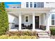 Inviting front porch with seating area, columns, stone accents, and manicured landscaping at 345 Somerled Way, Waxhaw, NC 28173