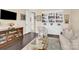 Inviting living room featuring dark hardwood floors, built-in shelving, a TV, and neutral furniture at 345 Somerled Way, Waxhaw, NC 28173